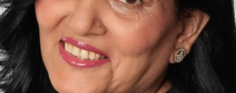 Smiling woman with black hair and earrings