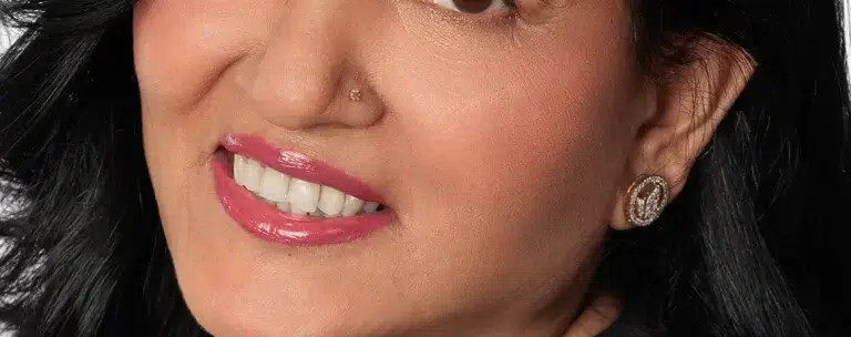 Smiling woman with dark hair and earrings